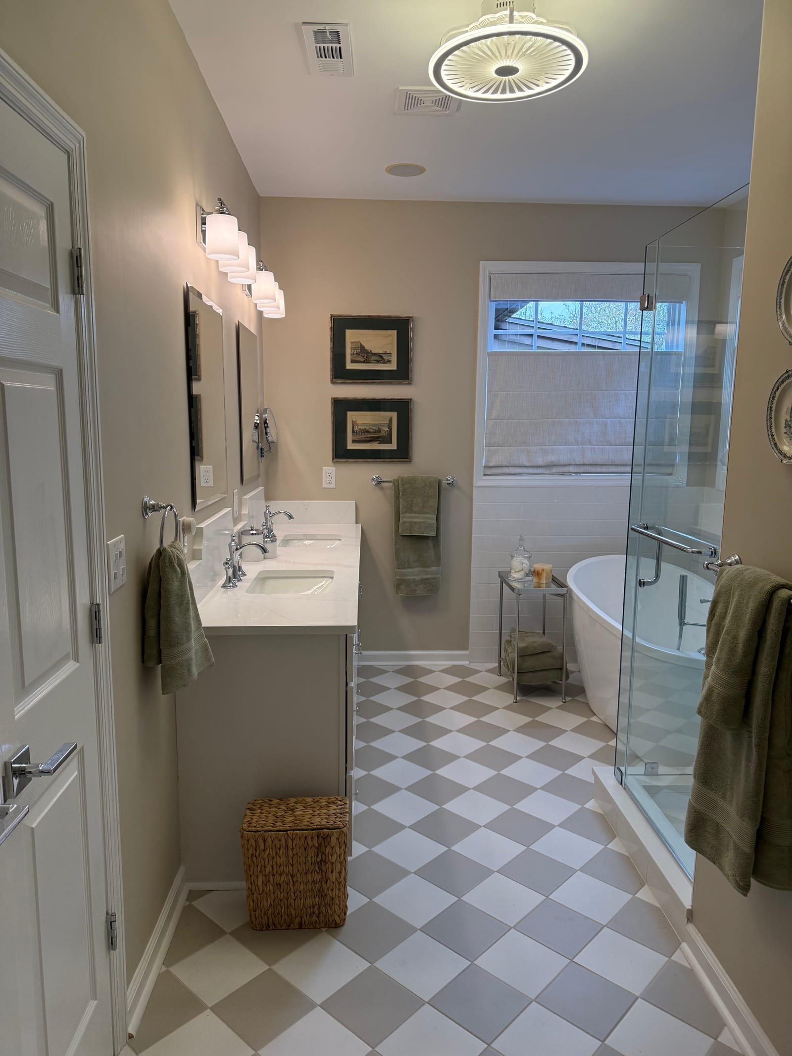 Completed bathroom remodel with a quartz-topped vanity, freestanding tub behind glass and a grey and white checkerboard tile floor