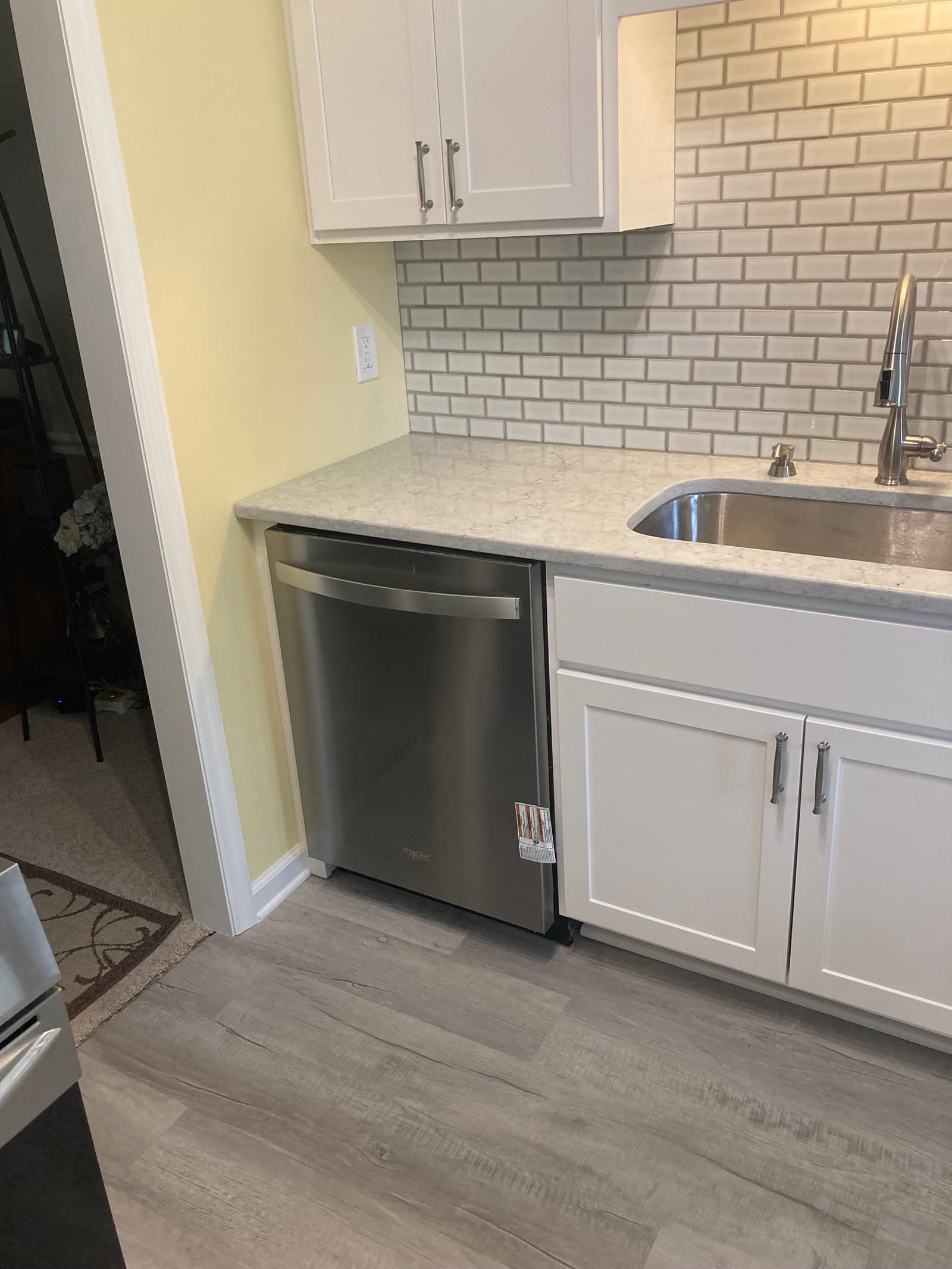Kitchen sink run with an integrated dishwasher, quartz worktop and subway tile backsplash