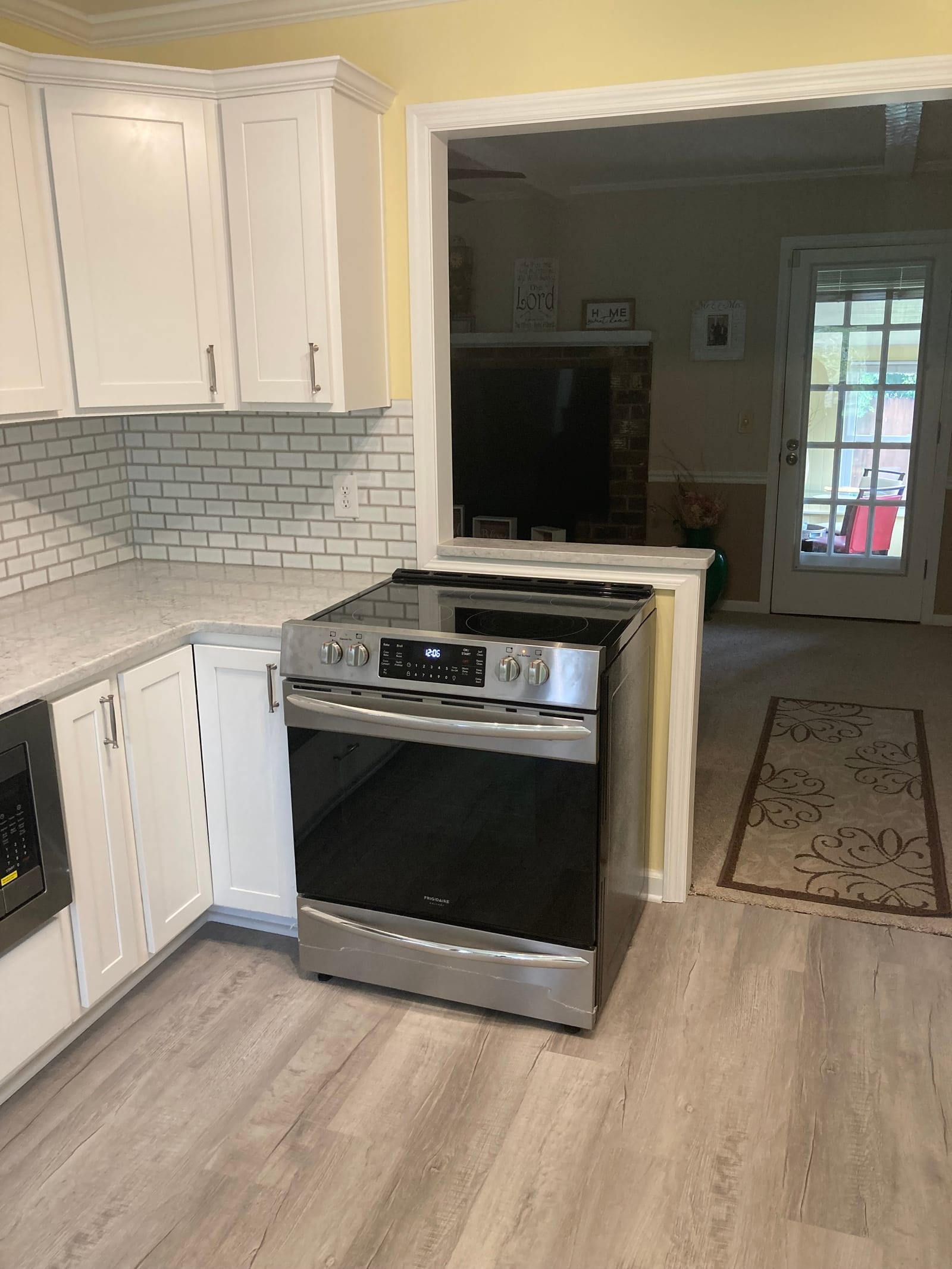 Kitchen remodel with white shaker cabinets, a subway tile backsplash and a slide-in electric range